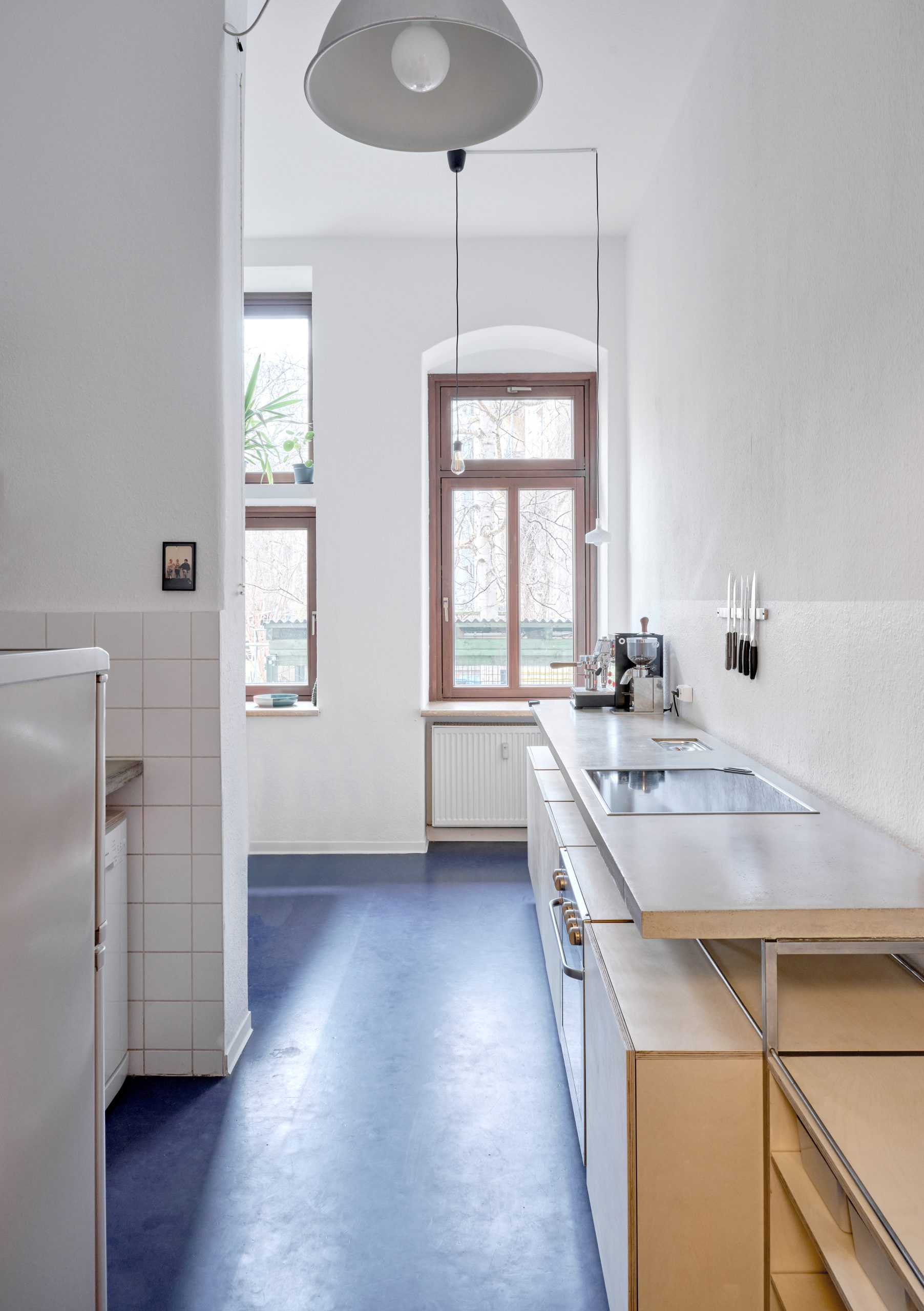 Blick durch einen schmalen Küchenraum mit Arbeitszeilen auf beiden Seiten